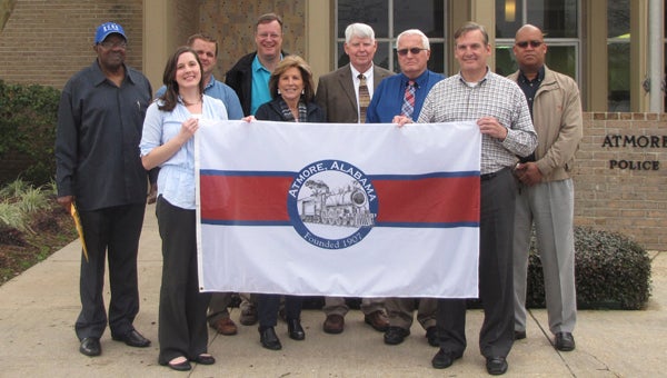 The Atmore City Council unanimously adopted the design for Atmore's first municipal flag. Pictured are, from left, City Councilman Cornell Torrence, Leadership Atmore Vice-president Sydney McGhee, Councilman Chris Harrison, Leadership Atmore member Ricky Martin, Councilwoman Susan Smith, Mayor Jim Staff, Councilman Webb Nall, Leadership Atmore President Bub Gideons and Councilman Chris Walker.