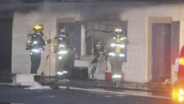 Firefighters make sure the flames are out in one of the rooms Saturday evening.|Photo by Justin Schuver
