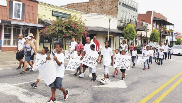 Participants join in Saturday’s march through downtown Atmore.