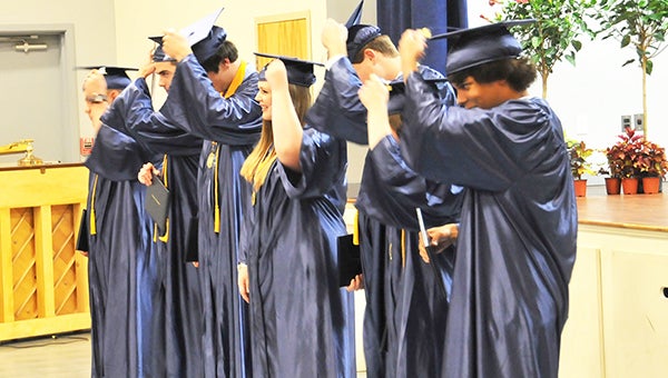 Atmore Christian School 2016 graduates Ethan Heller, Madelyn Boatwright, Nathan Jurjevich, Brandon Beachy, Christopher Gehman, Haleigh German and Canaan Zundel turn their tassels from one side to the other at the end of the ceremony Friday night.| Andrew Garner/ Atmore Advance