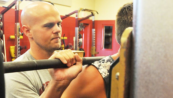 New Northview head football coach Derek Marshman helps a player lift weights Monday morning. Marshman was named the Chiefs’ football coach last Friday. | Andrew Garner/Atmore Advance